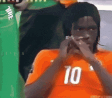 a soccer player wearing an orange jersey with the number 10 on it