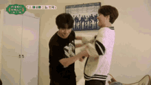 two men are standing next to each other in a room with a picture on the wall that says ' bts '