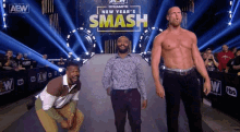 three men are standing in front of a sign that says ' new year 's smash '