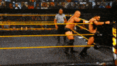 two men are wrestling in a ring that says nxt on the bottom