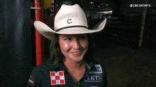 a woman wearing a cowboy hat with a c on it