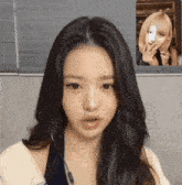 a woman with long hair is talking to another woman on a video call while holding a cell phone .