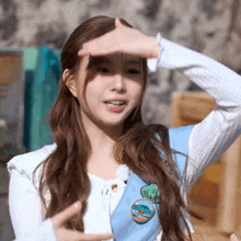 a girl wearing a white shirt and a blue sash with a badge that says scout on it