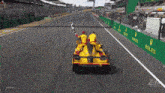 a race car is on a race track with rolex advertisements on the side