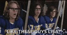 a group of hockey players are sitting in a locker room and one of them is wearing glasses and a blue jersey .