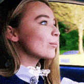 a woman is sitting in a car with a disney logo on her shirt