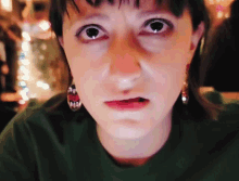 a close up of a woman 's face with a christmas tree in the background