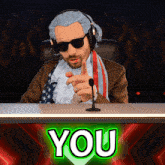 a man sitting at a desk with a green sign that says you on it