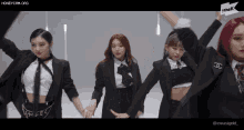a group of women in suits are dancing in front of a sign that says thek