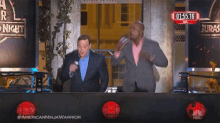two men are standing in front of a sign that says americanninjawarrior