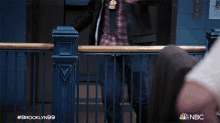 a man in a leather jacket and tie is dancing in an elevator with the hashtag #brooklyn99 on the bottom