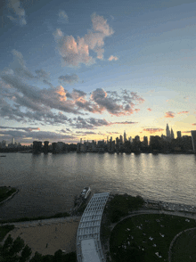 a sunset over a body of water with the city skyline in the background