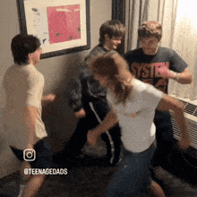 a man wearing a system of a down shirt is dancing with a girl