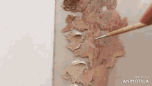 a person is painting a picture with a brush .