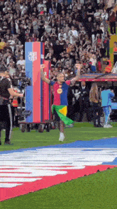 a man in a barcelona jersey stands on a soccer field holding a flag