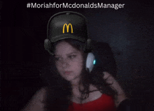 a girl wearing headphones and a mcdonald 's hat