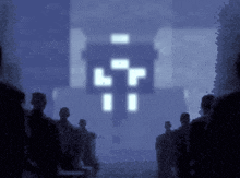 a group of people are standing in front of a pixelated image of a cross