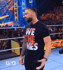 roman reigns is wearing a black t-shirt that says we the nes .