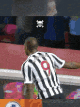a man in a black and white striped jersey with the number 9 on the back