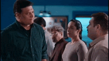 a man and a woman are standing next to each other in a room talking to each other .