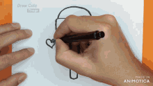 a hand draws a heart on a piece of paper