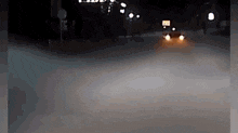 a car is driving down a road at night with a sign that says ' a ' on it