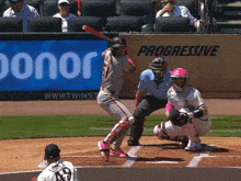 a baseball player swings at a pitch in front of a progressive ad