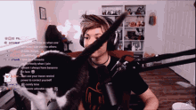 a man wearing headphones is playing with a cat on a twitch channel
