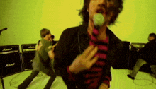 a man sings into a microphone in front of a marshall amplifier