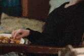 a person sitting in a chair with a plate of food
