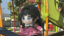 a stuffed doll in a pink dress is sitting on a slide at a playground