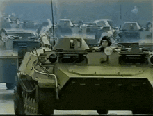 a man in a helmet driving a military vehicle