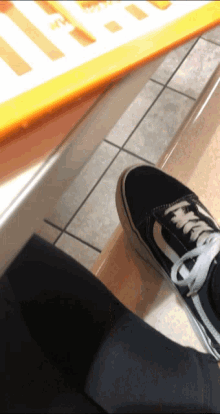 a person wearing a pair of black vans sneakers