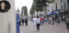 a man in a black jacket is driving down a street with a sign that says ' m & s ' on it