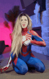 a woman in a spider man costume is kneeling down