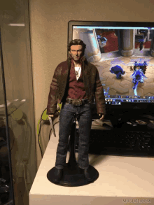 a figurine of wolverine standing in front of a computer screen