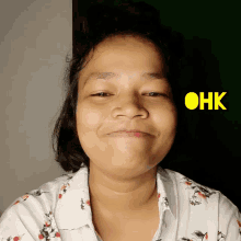 a woman making a funny face with the word ohk above her head