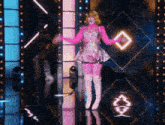 a woman in a pink dress and white boots stands on a stage with a diamond in the background
