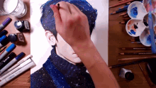 a drawing of a man with blue hair is being painted on a piece of paper