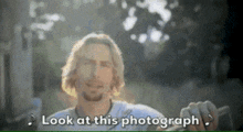 a man taking a picture with the words look at this photograph written below him