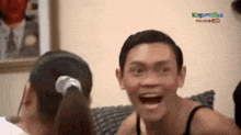 a man is making a funny face with his mouth open while sitting on a couch .
