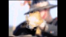 a blurry picture of a man in a hat with the letters mg on the bottom left