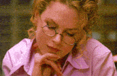 a woman wearing glasses and a pink shirt