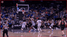 a basketball game is being played in front of a crowd with a tissot ad in the background .