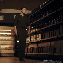 a man in a black shirt is walking down a store aisle with drink smoothly written on the bottom