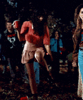a woman in a pink skirt holds a red cup