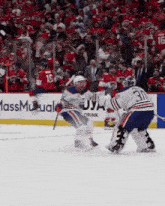 a hockey game is being played in front of an ad for massmutual