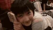 a young girl is laying on the floor holding a piece of paper in her hand .