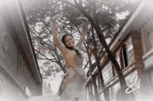 a woman in a white dress is dancing in front of trees and buildings