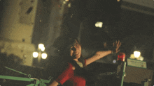 a girl in a red shirt is surrounded by confetti flying around her